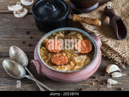 Weihnachts-Kohlsuppe in Keramikschale auf natürlichem Holzhintergrund. Stockfoto