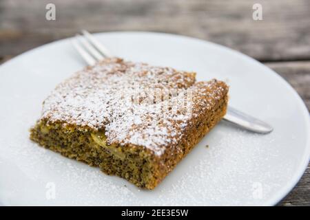 Eine Scheibe Mohnkuchen, serviert auf einem Teller, bedeckt mit Zuckerpulver Stockfoto