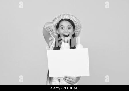 Kleines Mädchen Strohhut zeigt leeres Papier Kopieplatz, unglaubliche Chance Konzept. Stockfoto