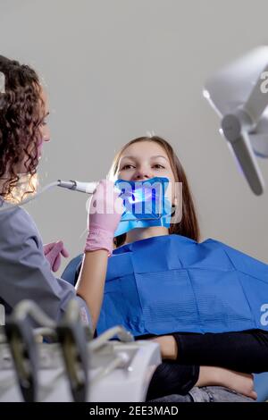 Laser Zahnaufhellung bei dantist Zimmer. Zähne, die für die Frau. Bleichen der Zähne beim Zahnarzt Klinik Stockfoto