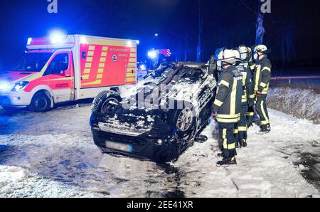 Oststeinbek, Deutschland. Februar 2021, 15th. Auf dem Dach der Landstraße zwischen Oststeinbek und Havighorst liegt nach einem Verkehrsunfall ein Auto. Der Fahrer hatte sein Auto auf der rutschigen und verschneiten Straße von der Straße gefahren, einen Baum getroffen und dann auf das Dach umgedreht. Dabei wurde der Mann verletzt. Quelle: Daniel Bockwoldt/dpa - ACHTUNG: Das Kennzeichen wurde aus rechtlichen Gründen pixeliert/dpa/Alamy Live News Stockfoto