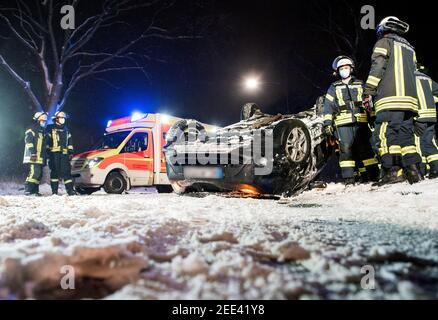 Oststeinbek, Deutschland. Februar 2021, 15th. Auf dem Dach der Landstraße zwischen Oststeinbek und Havighorst liegt nach einem Verkehrsunfall ein Auto. Der Fahrer hatte sein Auto auf der rutschigen und verschneiten Straße von der Straße gefahren, einen Baum getroffen und dann auf das Dach umgedreht. Dabei wurde der Mann verletzt. Quelle: Daniel Bockwoldt/dpa - ACHTUNG: Das Kennzeichen wurde aus rechtlichen Gründen pixeliert/dpa/Alamy Live News Stockfoto