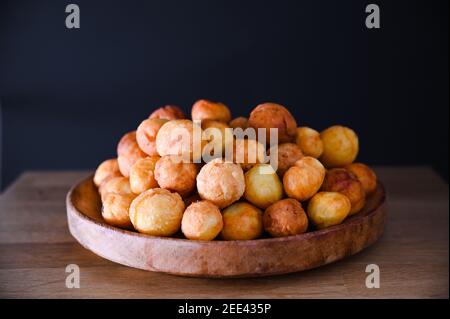 Gebackene castagnole auf Holzhintergrund. Street Food, runde Kekse mit Zucker für den Karneval von Venedig. Traditionelle süße Backwaren während der Karnevalszeit in italien. Speicherplatz kopieren Stockfoto