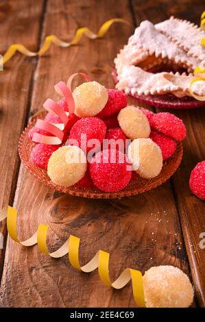 Farbige Castagnole. Traditionelle süße Backwaren während der Karnevalszeit in italien. Street Food, runde Kekse mit Zucker für den Karneval von Venedig. Platz kopieren. Vertikales Foto Stockfoto