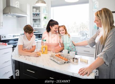 Eine Familie, die zusammen Frühstück macht und lacht Stockfoto