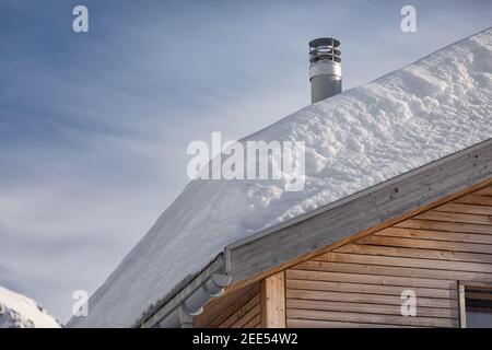 Schneebedecktes Dach eines Holzhauses in der schweiz Stockfoto
