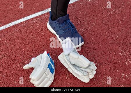 Weiße Cricket-Handschuhe links auf dem Platz bei der Spieler Fuß Stockfoto