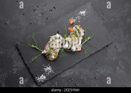 Sandwiches mit Fischtüll auf schwarzem Hintergrund. Brussquettes Stockfoto