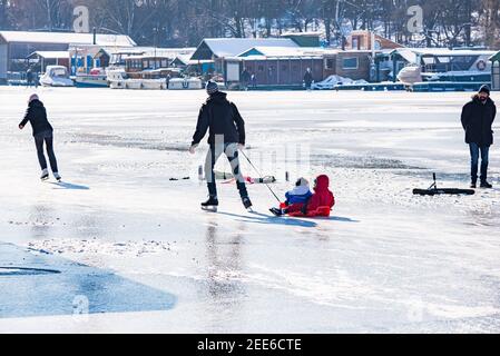 Prag, Tschechische republik - 14. Februar 2021. Familie Eislaufen auf gefrorenem Fluss Moldau - Moldau in Bach Stockfoto