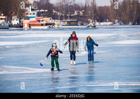 Prag, Tschechische republik - 14. Februar 2021. Kinder mit Mutter Eislaufen auf gefrorenem Fluss Stockfoto