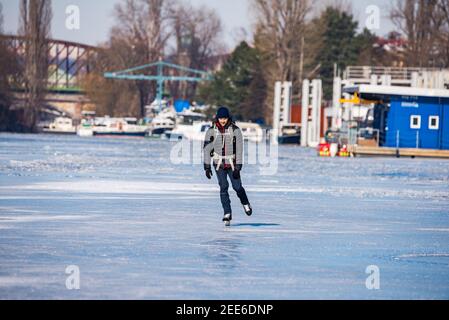 Prag, Tschechische republik - 14. Februar 2021. Ein Mann mittleren Alters Eislaufen auf gefrorenem Fluss Stockfoto