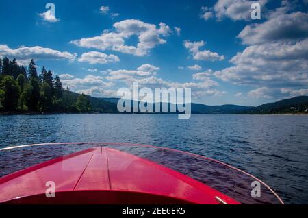 Blick über den Bug eines roten Motorbootes zum Schluchsee im Schwarzwald Stockfoto