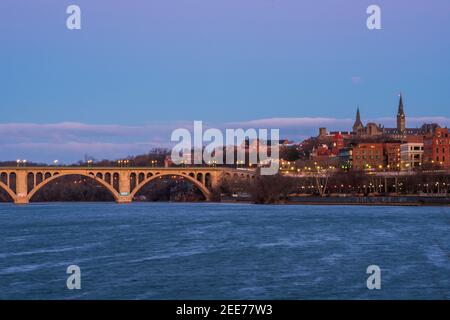 Der Vollmond geht im frühen Morgenlicht über der Key Bridge in Washington, DC, unter. Stockfoto