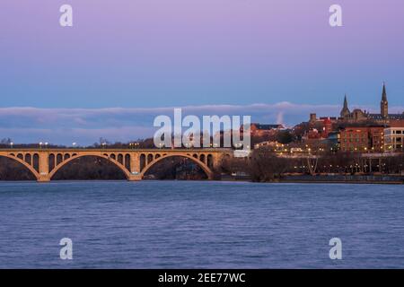 Der Vollmond geht im frühen Morgenlicht über der Key Bridge in Washington, DC, unter. Stockfoto