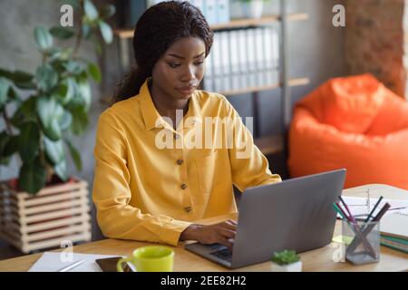 Foto Porträt von afroamerikanischen Frau arbeiten auf Laptop-Eingabe Im modernen Büro im Innenbereich Stockfoto