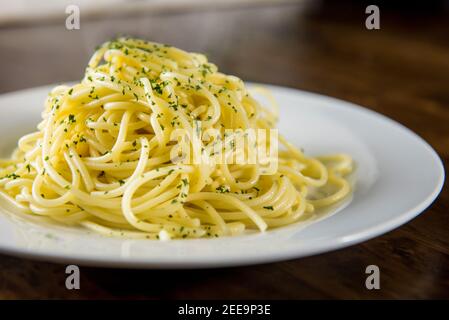 Hausgemachte gekochte italienische Spaghetti mit gemahlener Petersilie auf Weiß Platte am Tisch Stockfoto