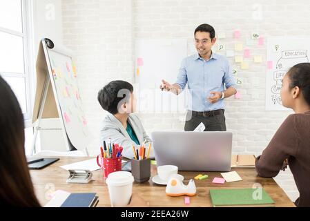 Schöner asiatischer männlicher Lehrer, der Erklärung zur weiblichen Übersee Hochschule gibt Schüler im Klassenzimmer - Bildungskonzept Stockfoto