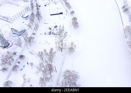 Leerer Outdoor-Sportplatz im Winterpark mit Schnee bedeckt. Luftaufnahmen mit Drohne Stockfoto