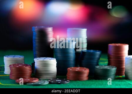 Blur Hintergrund und Chips, Stapel von Poker-Chips auf einem grünen Tisch. Poker-Spiel Thema. Stockfoto