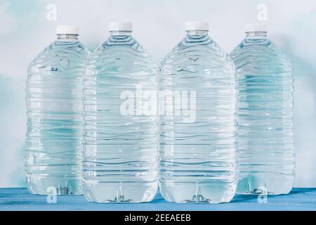 Plastikflaschen Wasser auf blauem Hintergrund, frisches Trinkwasser aus nächster Nähe Stockfoto