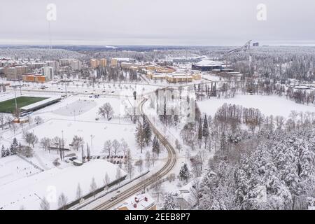 Lahti, Finnland 14. Februar 2021. Foto von der Drohne. Blick auf die Stadt, schneebedeckte Wohngebäude und Straßen, teilweise bewaldete Gegend. Der Tag ist bewölkt, Winter. Hochwertige Fotos Stockfoto