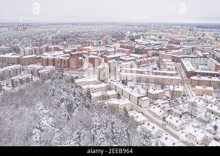 Lahti, Finnland 14. Februar 2021. Foto von der Drohne. Blick auf die Stadt, schneebedeckte Wohngebäude und Straßen, teilweise bewaldete Gegend. Der Tag ist bewölkt, Winter. Hochwertige Fotos Stockfoto