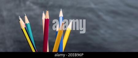 Verschiedene bunte scharfe Bleistifte auf verschwommenem Kreidetafel Hintergrund, Panorama-Banner mit Copy Space Stockfoto