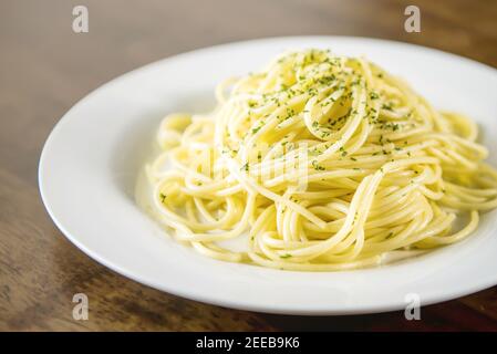 Gekochte italienische Spaghetti mit gemahlener Petersilie auf weißem Teller Stockfoto