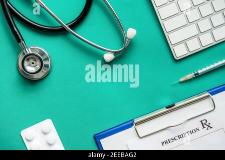 Medizinische Geräte einschließlich Stethoskop, Spritze, Rezept und Medikamente auf grünem Hintergrund, Draufsicht flach legen Stockfoto