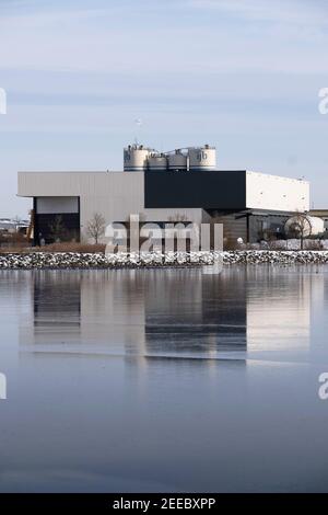 Fabrik und Büro von 'Polem', dem Hersteller von Verbundsilos und Tanks in Lemmer und der 'IJB-Gruppe', spiegelt sich im gefrorenen Eis der Bucht von Lemmer wider Stockfoto