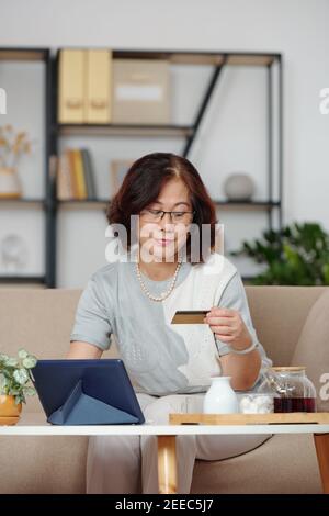 Ältere Frau genießt Online-Shopping Stockfoto