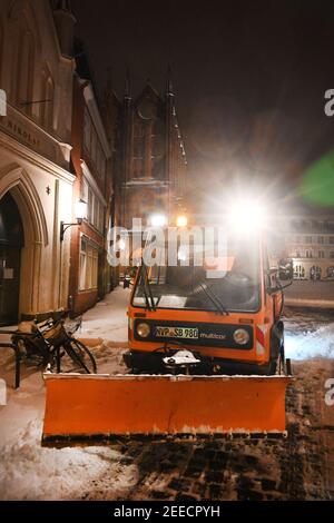 Stralsund, Deutschland. Februar 2021, 16th. Ein Lichtung- und Gitterfahrzeug ist heute früh auf einer verschneiten Straße in der Stadtgrenze unterwegs. Quelle: Stefan Sauer/dpa-Zentralbild/dpa/Alamy Live News Stockfoto