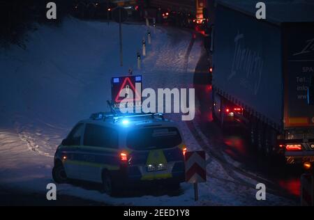 Waidhaus, Deutschland. Februar 2021, 16th. Ein Polizeiauto kündigt am frühen Morgen einen Scheck an der deutsch-tschechischen Grenze an, daneben stehen Fahrzeuge. In der Nacht vom 14,02.2021 traten die strengeren Einreisebestimmungen Deutschlands an der Grenze zur Tschechischen Republik zum Schutz vor gefährlichen Varianten des Coronavirus in Kraft. Quelle: Armin Weigel/dpa/Alamy Live News Stockfoto