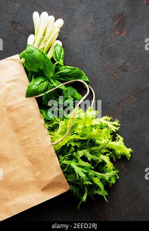 Frisches Grün in einer Papiertüte auf schwarzem Hintergrund Stockfoto