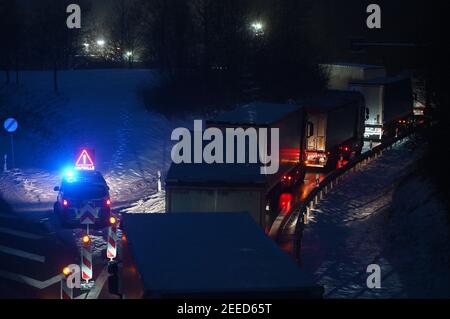 Waidhaus, Deutschland. Februar 2021, 16th. Ein Polizeiauto kündigt am frühen Morgen einen Scheck an der deutsch-tschechischen Grenze an, daneben stehen Fahrzeuge. In der Nacht vom 14,02.2021 traten die strengeren Einreisebestimmungen Deutschlands an der Grenze zur Tschechischen Republik zum Schutz vor gefährlichen Varianten des Coronavirus in Kraft. Quelle: Armin Weigel/dpa/Alamy Live News Stockfoto
