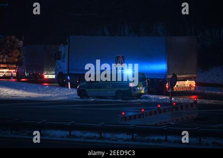 Waidhaus, Deutschland. Februar 2021, 16th. Ein Polizeiauto kündigt am frühen Morgen einen Scheck an der deutsch-tschechischen Grenze an, daneben stehen Lastwagen in einem Stau. In der Nacht vom 14,02.2021 traten die verschärften Einreisebestimmungen Deutschlands an der Grenze zur Tschechischen Republik zum Schutz vor gefährlichen Varianten des Coronavirus in Kraft. Quelle: Armin Weigel/dpa/Alamy Live News Stockfoto