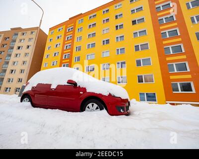 Verlorenes Auto unter riesigen Schnee und gelb orange Wohnsitz Haus In einer Straße im Winter Stockfoto