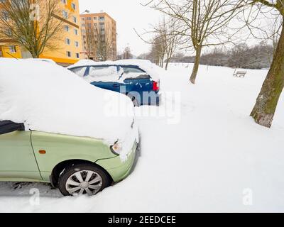 Parcot Auto bedeckt mit Schnee in der Wintersaison. Autos unter großer Schneedecke von Nacht Schneesturm Stockfoto