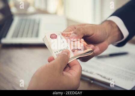 Geschäftsmann Geld geben, russische Rubel Währung, um hs-Partner - Zahlung, Darlehen und Bestechung Konzept Stockfoto