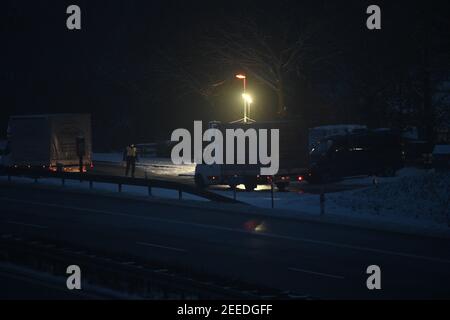 Waidhaus, Deutschland. Februar 2021, 16th. Kurz nach der deutsch-tschechischen Grenze steht am frühen Morgen bei einem Check ein Polizist auf einem Parkplatz. In der Nacht vom 14,02.2021 traten die verschärften Einreisebestimmungen Deutschlands an der Grenze zur Tschechischen Republik zum Schutz vor gefährlichen Varianten des Coronavirus in Kraft. Quelle: Armin Weigel/dpa/Alamy Live News Stockfoto