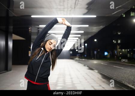 Frau streckt ihre beiden Hände vor ihrem Outdoor-Training Stockfoto