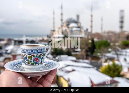 Türkischer Kaffee mit blauer Moschee im Hintergrund in Istanbul, Türkei. Türkischer Kaffee mit traditioneller Porzellanschale. Stockfoto