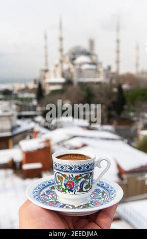 Türkischer Kaffee mit blauer Moschee im Hintergrund in Istanbul, Türkei. Türkischer Kaffee mit traditioneller Porzellanschale. Stockfoto