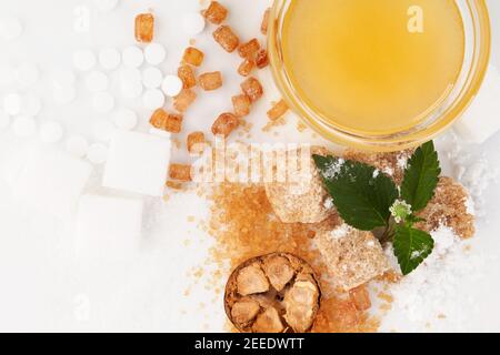 Verschiedene Arten von Zucker - braun, weiß, Kristall, Pulver und Rohrzucker, künstliche Süßstoffe, Mönchsfrucht und Honig in Schüssel. Stockfoto