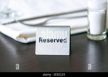 Reserviertes Schild, Eisenplatte auf dem Tisch im Café oder Restaurant, getöntes Bild Stockfoto