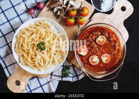Draufsicht, Spaghetti Pasta Nudel mit Bolognese Tomatensoße und frische Zutaten Stockfoto