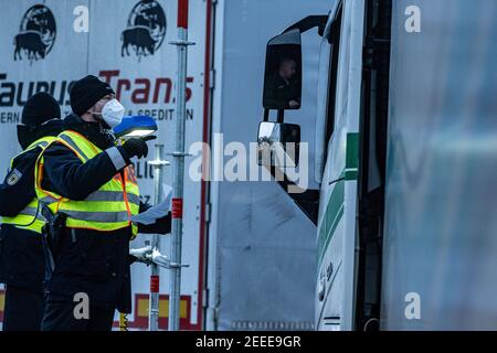 Waidhaus, Deutschland. Februar 2021, 16th. Polizeibeamte überprüfen Fahrer von Lastwagen auf einem Parkplatz kurz nach der deutsch-tschechischen Grenze. In der Nacht vom 14,02.2021 traten die verschärften Einreisebestimmungen Deutschlands an der Grenze zur Tschechischen Republik zum Schutz vor gefährlichen Varianten des Coronavirus in Kraft. Quelle: Armin Weigel/dpa/Alamy Live News Stockfoto