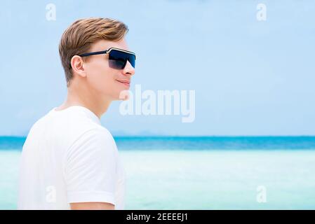 Lächelnder, zwangloser Tourist mit Sonnenbrille am Strand Sommerurlaub Stockfoto