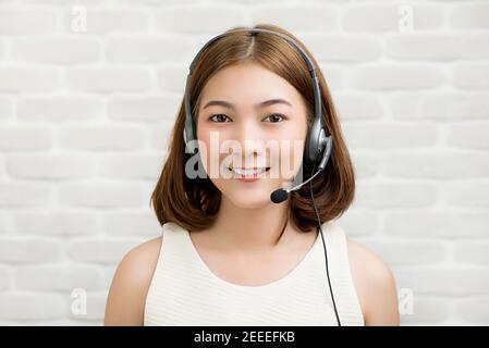 Lässige asiatische Geschäftsfrau trägt Mikrofon-Headset als Telemarketing-Kundendienstmitarbeiter, Call-Center-Job-Konzept Stockfoto