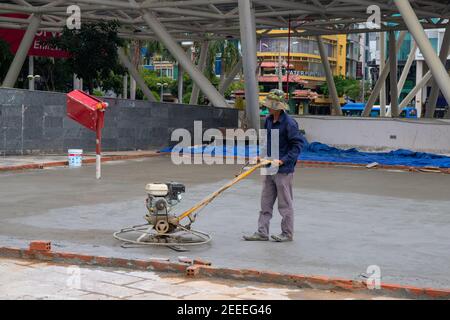 Saigon, Vietnam - 18. Juli 2019: Arbeiter macht Beton gießen. Asphalt Renovierung Straßenarbeiten. Park Straße Pflasterung Prozess. Straßenbauausrüstung. Fl Stockfoto